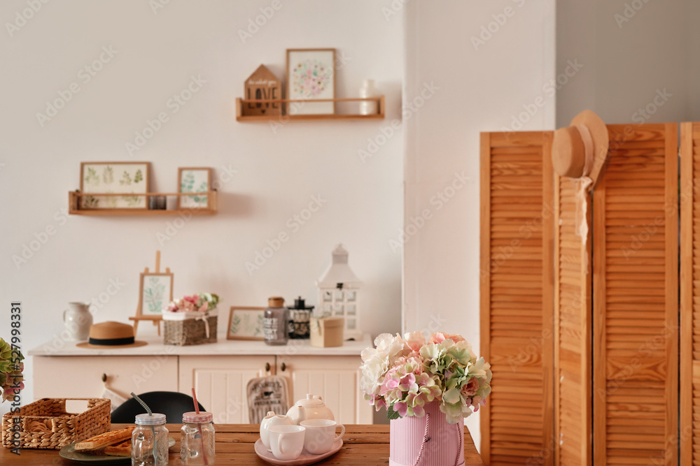 White kitchen interior in loft style. Shelves with pink crockery and kitchen utensils. Studio apartment. Rent and delivery of housing. Hostel and hotel White kitchen interior in loft style. Shelves with pink crockery and kitchen utensils. Studio apartment. Rent and delivery of housing. Hostel and hotel