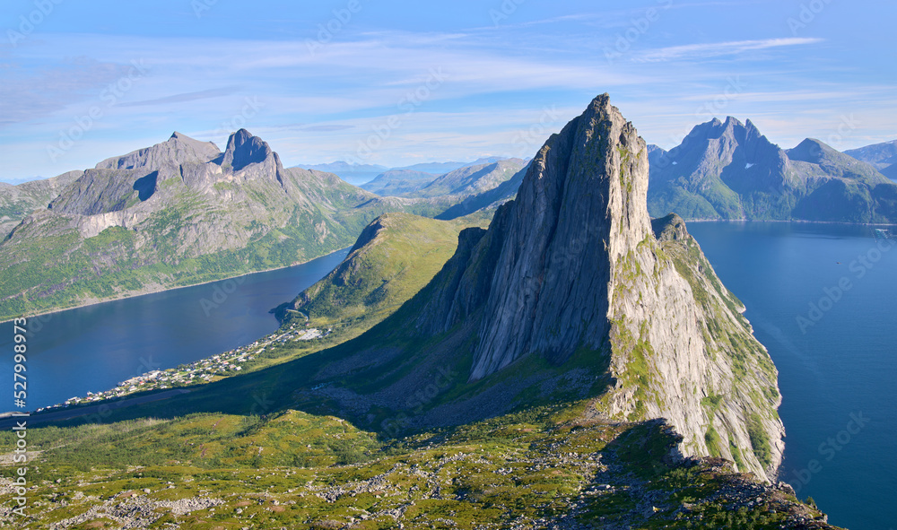 View from the mount Hesten on iconic mountain Segla in a summer sunny day. Mountain ranges at the background. Fjordgard, Senja island, Norway. Summer vacation in Lofoten   