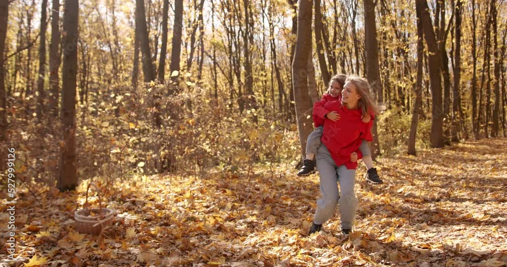 Young blond mother with daughter walk in the autumn forest Young blond mother with daughter walk in the autumn forest