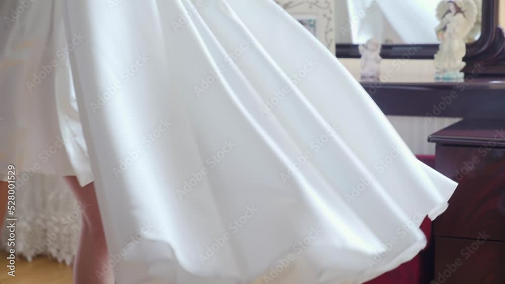 the bride takes off her wedding dress and posing near mirrow. Rotating the dress the bride takes off her wedding dress and posing near mirrow. Rotating the dress