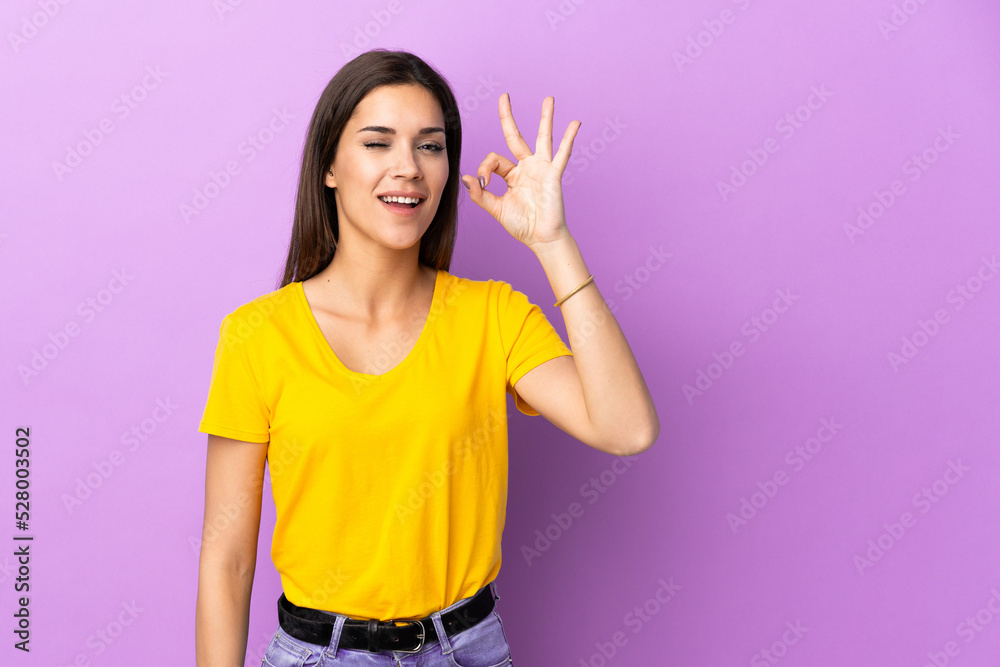 Young caucasian woman over isolated background showing ok sign with fingers Young caucasian woman over isolated background showing ok sign with fingers