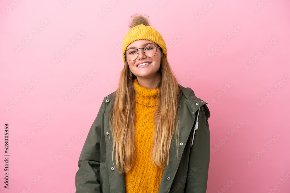 Young blonde woman wearing winter jacket isolated on pink background with glasses and happy Young blonde woman wearing winter jacket isolated on pink background with glasses and happy