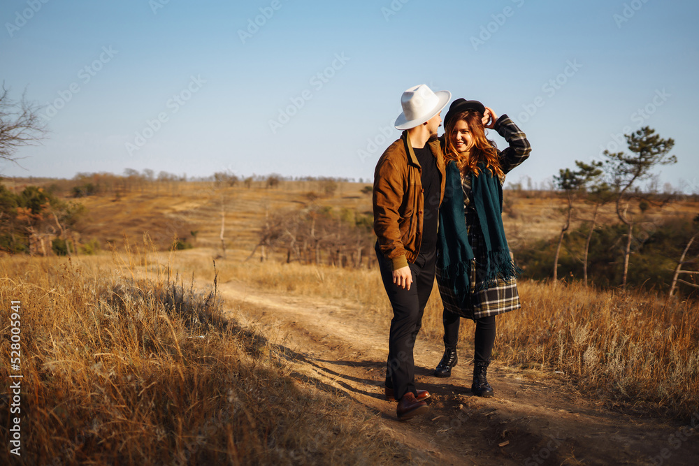 Stylish couple walking and hugging in the park. People, lifestyle, relaxation and vacations concept. Autumn Fashion, style concept.
