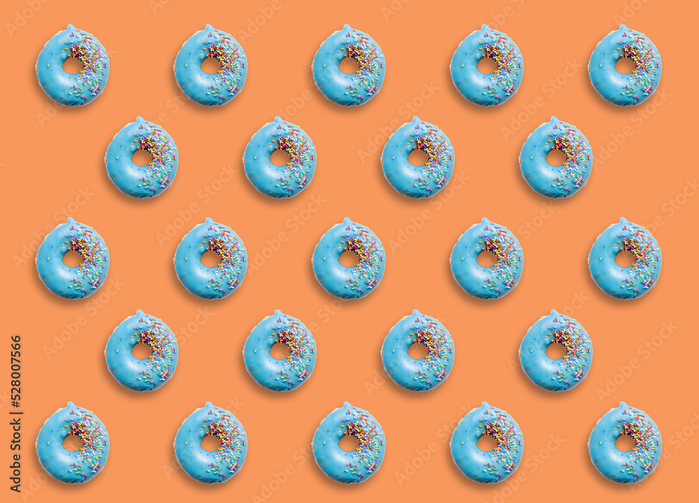Collage and background of donuts covered with colorful sprinkles on a orange background.