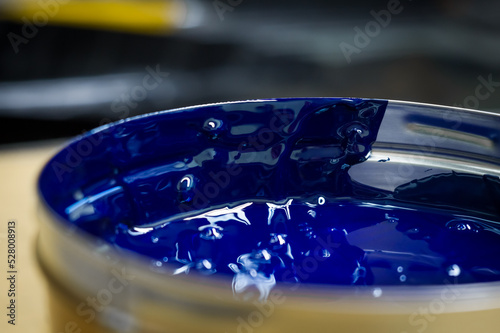 A can of blue polygraph offset paint for the printing press. Special UV ink for printing. Cyan color. Open new can of blue paint. Selective focus