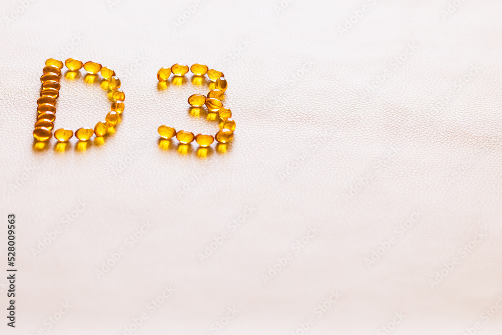 Bright oil yellow pills forming shape D3. Vitamin D3 capsules. Medicine vitamins and dietary supplements. Selective focus. Bright oil yellow pills forming shape D3. Vitamin D3 capsules. Medicine vitamins and dietary supplements. Selective focus.