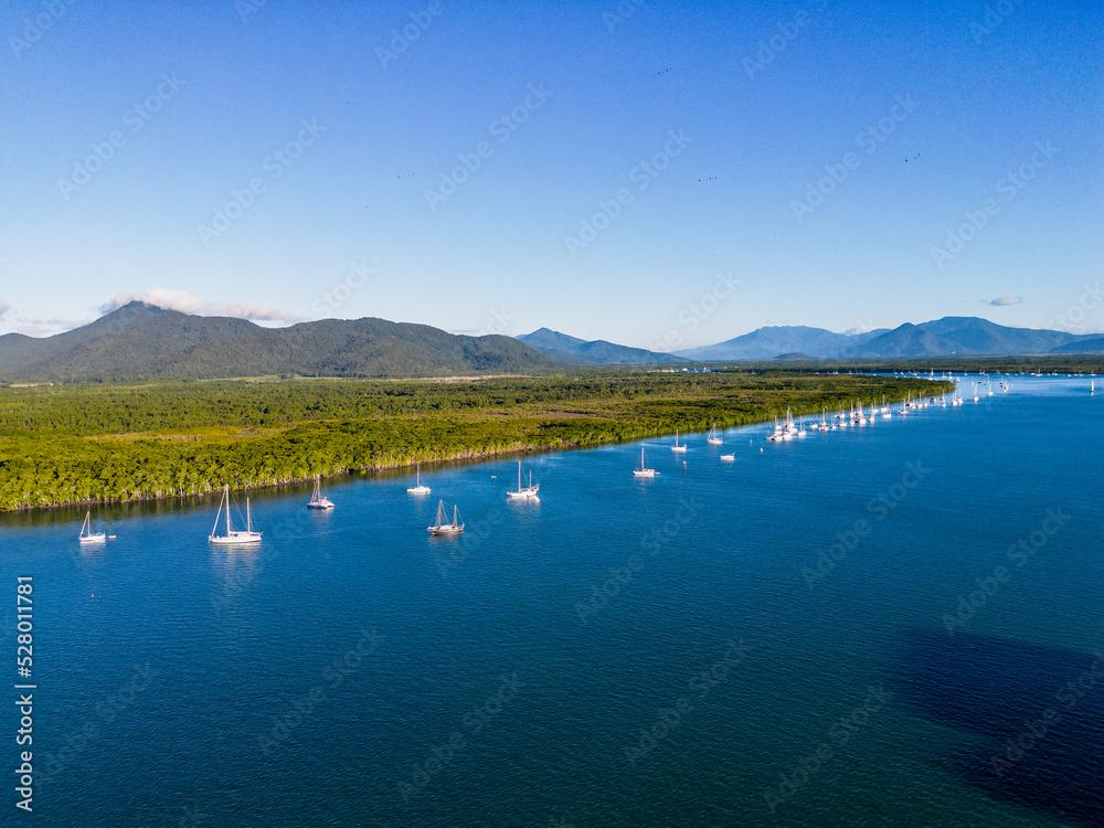 Aerial photo of perfect blue water and sky with mountains and boats
