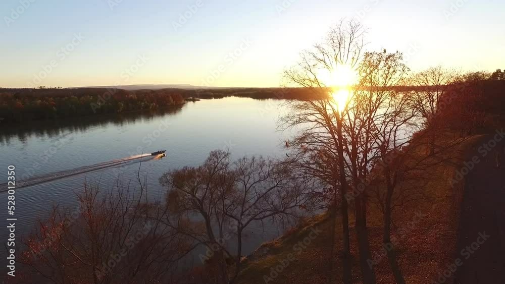 Arial view of boat on rover in Arkansas during fall foliage near Spadra recreation boating area of clarksville AR near sunset Arial view of boat on rover in Arkansas during fall foliage near Spadra recreation boating area of clarksville AR near sunset
