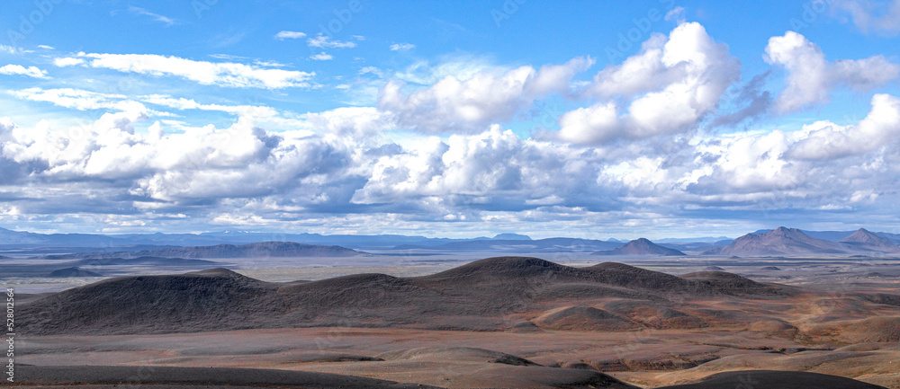 Landscape of Iceland of blak fields and mountains with a big clouds