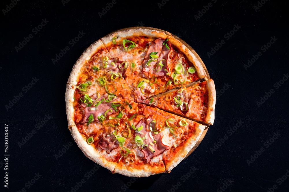 Delicious pizza with mozzarella cheese, ham, leeks on a tomato base. Top view