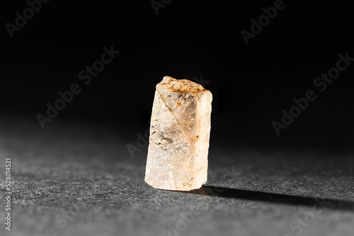 Rough uncut Yellow Topaz stone sample on black photo