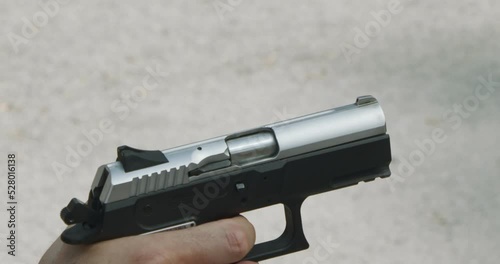 Pistol shooting bullets in slow motion footage. Hand guns in firing range photo