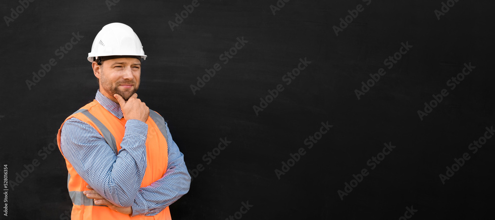 Male Engineer in a White Hard Hats and Orange West. Handsome Confident Build Worker Isolated on Blank Black Background. Copy Space. He Work in a Heavy Industry Manufacturing Factory. Mechanic Service Male Engineer in a White Hard Hats and Orange West. Handsome Confident Build Worker Isolated on Blank Black Background. Copy Space. He Work in a Heavy Industry Manufacturing Factory. Mechanic Service