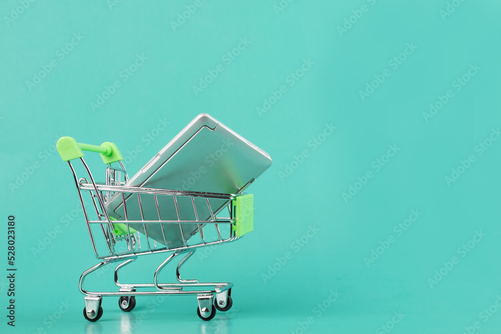 laptop in a shopping cart, computer in a supermarket trolley, black Friday, buying modern gadgets, sale, digital store