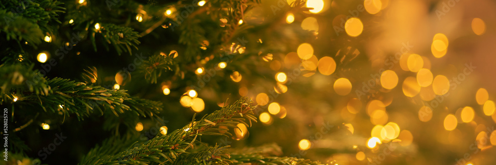 © yta - christmas tree banner with a garland of lights on a blurred background