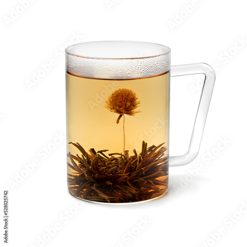 Glass cup with an Asian dried Jasmine tea flower and tea 
 isolated on white background photo