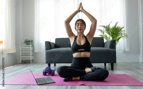 Portrait of young beautiful asian woman stretching warm up exercise workout yoga position at home in living room. Sporty asia girl health care lifestyle.
