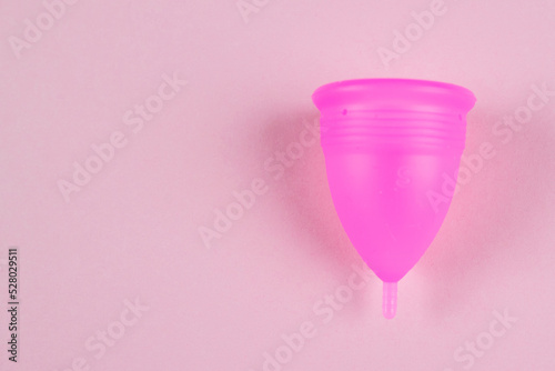 pink female menstrual cup on a pink background. Feminine hygiene. Menstruation. Place for text.