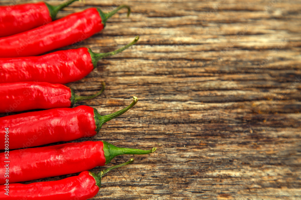 Red chili peppers on the table. Composition of red chili peppers and other spices. The concept of spices, seasonings, traditional cuisine.