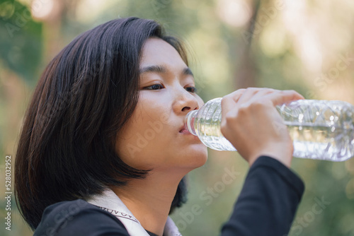 One asian beautiful woman drinking water on camping camp
