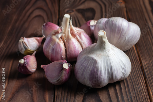 Garlic cloves on wooden table. Fresh peeled garlics and bulbs.