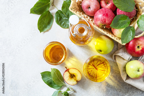 Apple juice in a glass and fresh apples on a stone tabetop. Autumn vitamin drink juice apple. View from above. Copy space. photo