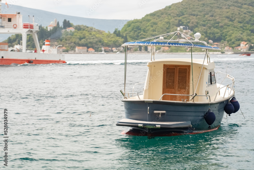 an old wooden fishing boat of white color is standing on the pier waiting for fishing. An old fishing boat. Water transport for fishing. an old wooden fishing boat of white color is standing on the pier waiting for fishing. An old fishing boat. Water transport for fishing.