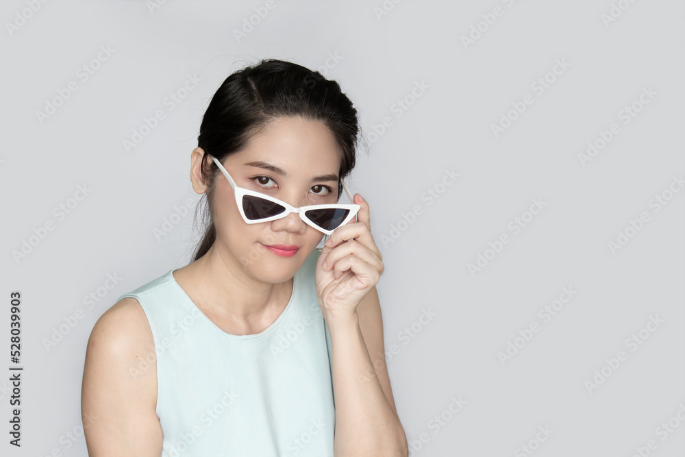 Portrait of Asian beautiful woman peeking over sunglasses with inquisition. Portrait of Asian beautiful woman peeking over sunglasses with inquisition.