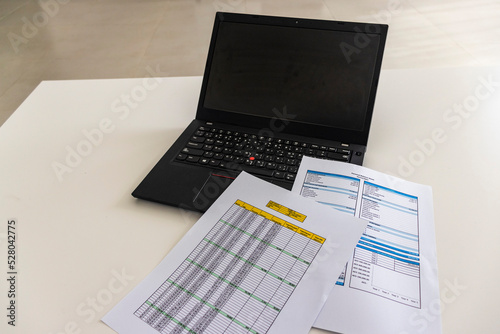 Close up shot of a print outs of excel table of a bank loan amortization table, personal balance sheet and laptop. Banking