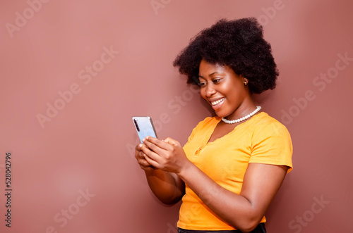 Portrait African American businesswoman using phone isolated on brown background