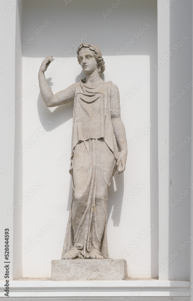 old sculpture of woman goddess in front of classic style house. Female statue in a european garden old sculpture of woman goddess in front of classic style house. Female statue in a european garden