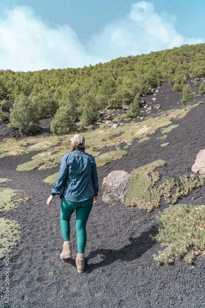 Naklejka premium Woman hiking on Mount Etna. It's a active vulcano in Sicily.