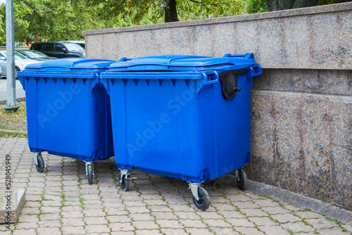 Blue plastic trash recycling containers. Blue containers for collecting garbage on the dustbin.