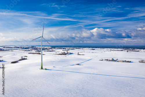 Wind turbine on white field. Alternative energy in winter. © shaiith