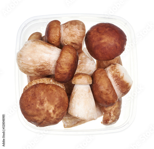 Plastic container with mushroom boletus. Top view of raw vegetables isolated on white background. Preparing vegetables for freezing. Storage for winter storage in trays