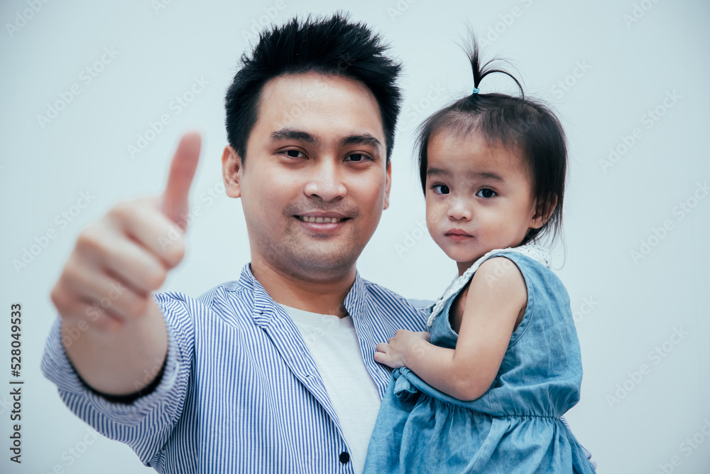 Head shot portrait young handsome bearded man cuddling little school aged kid daughter, standing together in white room. Head shot portrait young handsome bearded man cuddling little school aged kid daughter, standing together in white room.