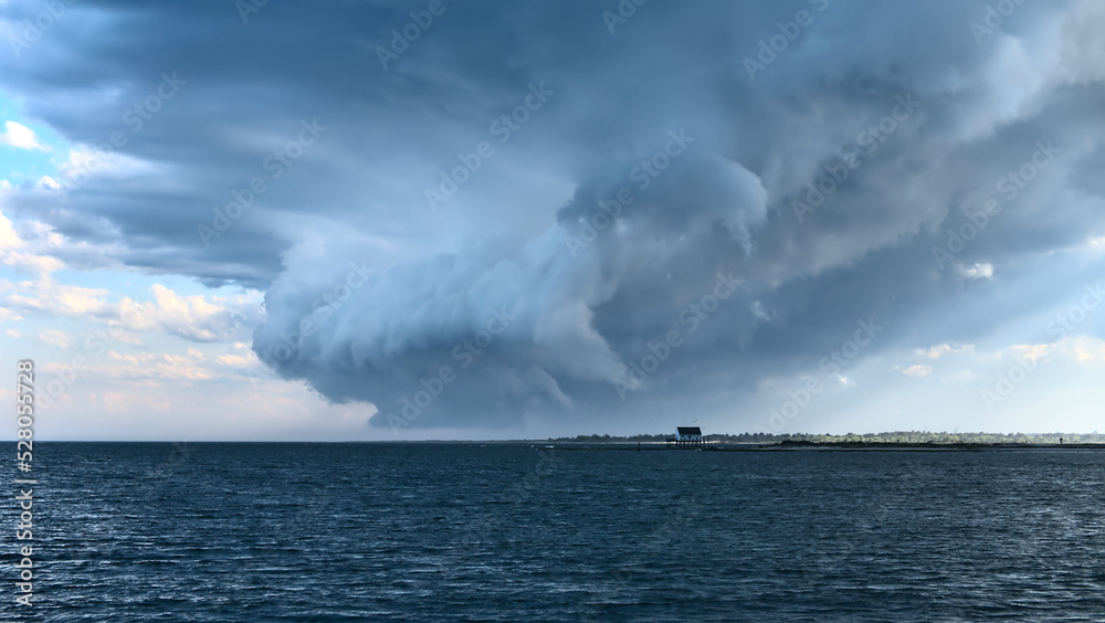 storm over the sea, formation of a tornado on a small house 