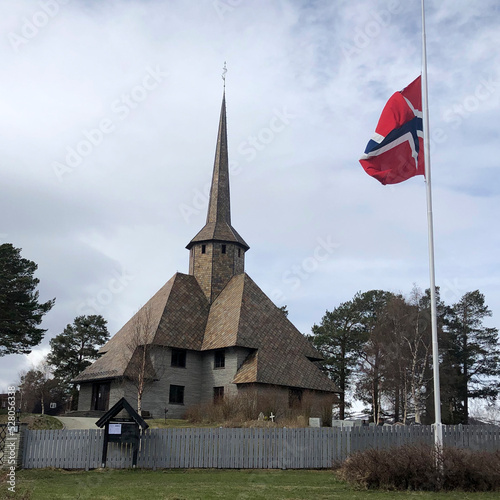Dombås Church with Norwegian flag (Norwegian: Dombås kirke) is a parish church of the Church of Norway, Dovre Municipality, Innlandet county. Best Norwegian architecture. Old traditional Norway church photo