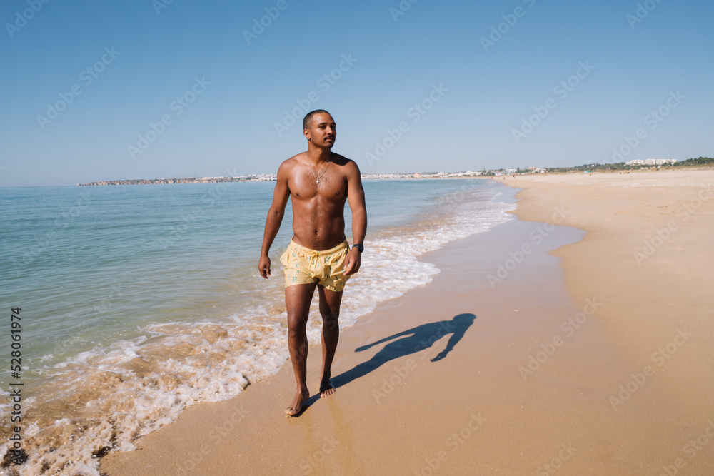 BOY WALKING ON THE BEACH ON A HAPPY VACATION