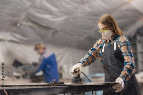 Fotobehang Closeup working of grinder on wood, woman carpenter performs work in protective clothing and respirator