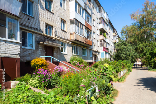 green urban courtyard of old apartment house in Yoshkar-Ola city on sunny summer day photo