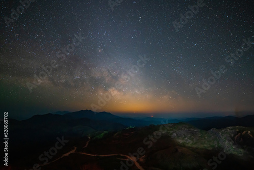 Panorama view universe space shot of milky way galaxy with stars on night sky background at mountains and city light landscape Thailand