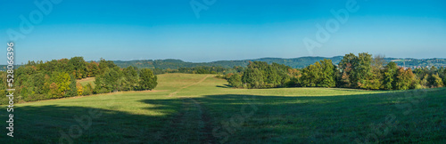 Panoramic late summer landscape with idyllic green meadow, trees, forest and hills with clear blue sky, Czech republic, central bohemia