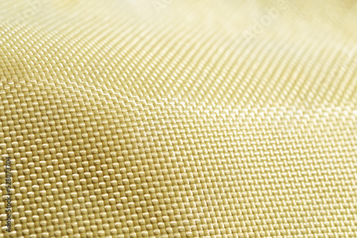 Bulletproof material aramid. Shining aramid kevlar background. Yellow kevlar texture and pattern.