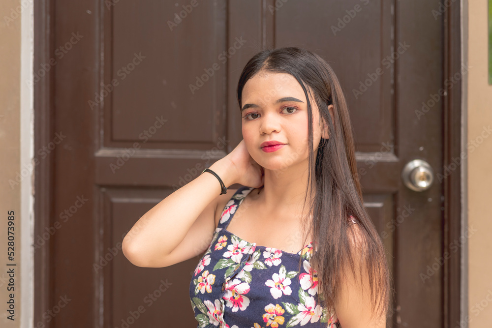 A pretty young girl stands in front of the main door as she poses for ...