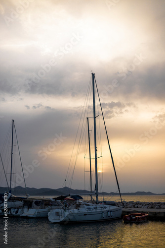 Small harbor with yachts and sail boats in at sunset © zlatkozalec