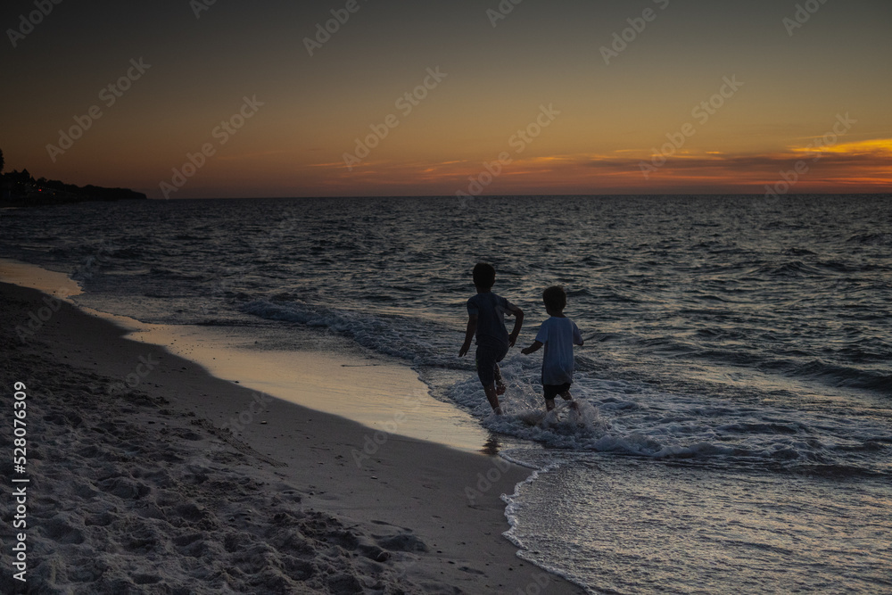 Sarbinowo poland August 2022, unidentfied children play by the Baltic sea in the evening