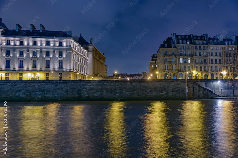 the Seine Rive in Paris at night with city light and buildings