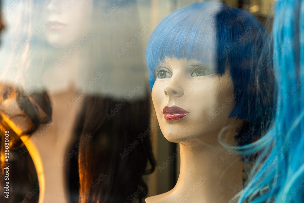 Female mannequin heads with wigs, behind a wig shop window Female mannequin heads with wigs, behind a wig shop window