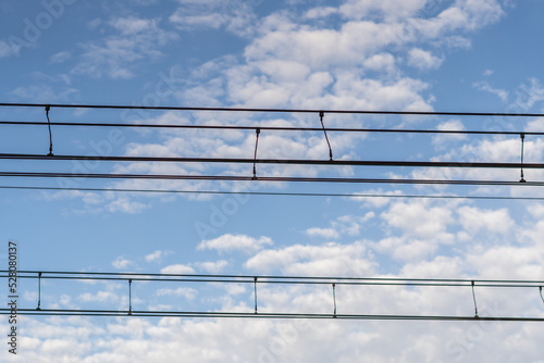 Railway catenary against blue sky photo